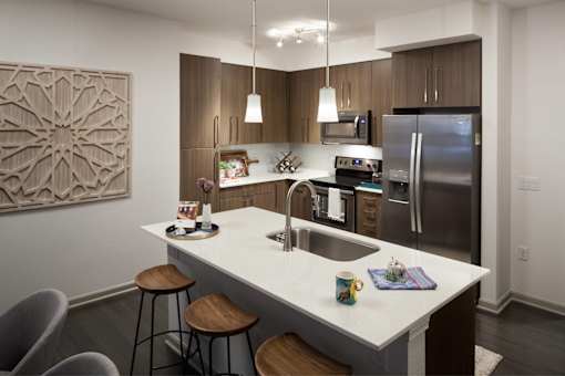 A modern kitchen with a white countertop and stainless steel appliances.