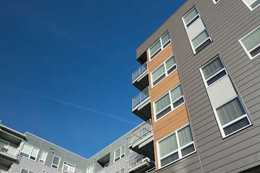 A modern apartment building with balconies and a clear blue sky.