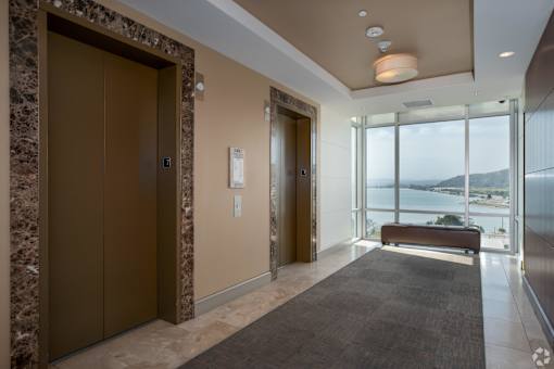 A modern hallway with a brown door and a bench.