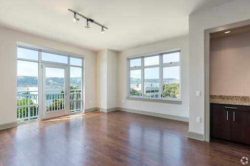 A spacious room with a view of the city through the windows.