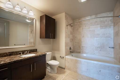 A bathroom with a marble countertop and a walk-in shower.