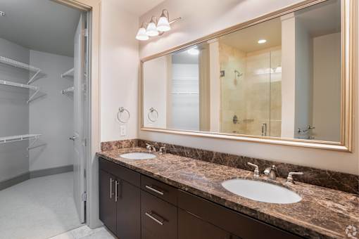A bathroom with a marble countertop and a large mirror.