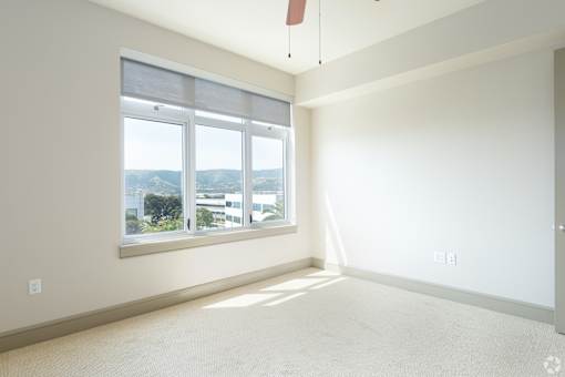 A room with a large window and a view of the city.