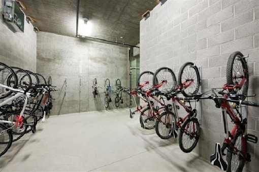 A bike rack with many bikes parked in a garage.