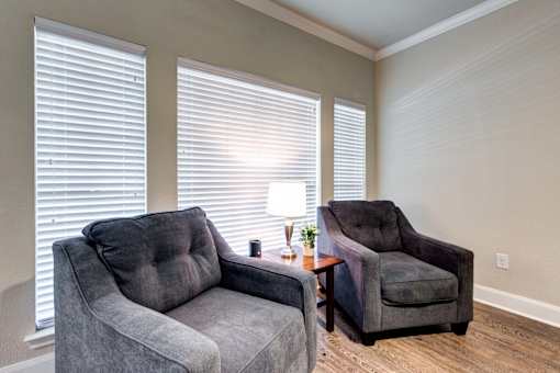 Two grey couches in a room with a table between them.