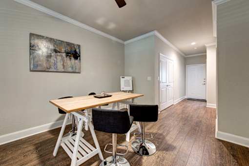 A room with a wooden table and black chair.