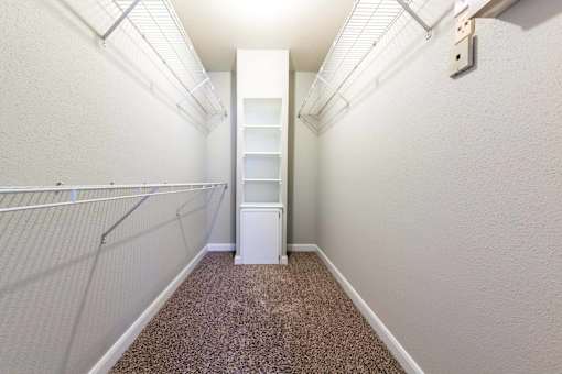 A long, narrow hallway with a white cabinet and a carpeted floor.