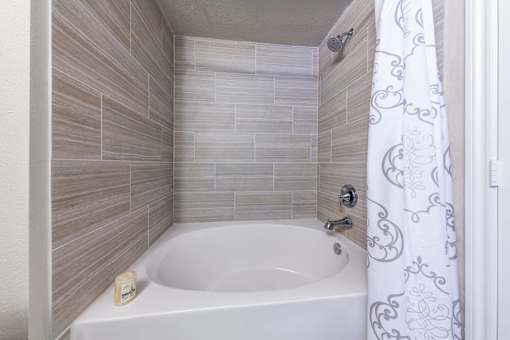 A white bathtub with a shower curtain in a bathroom.