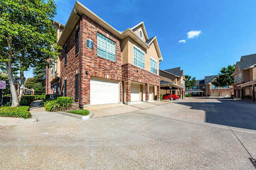 A residential building with a red car parked in front.
