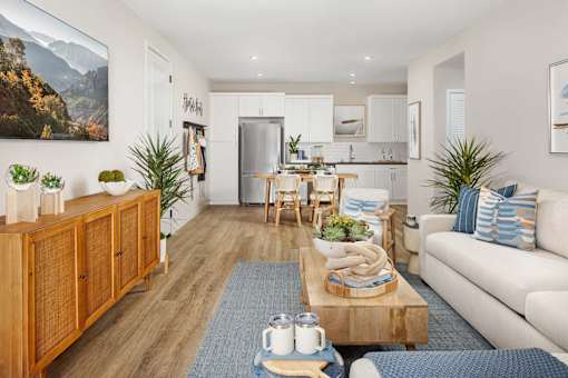 A living room with a wooden floor and a large painting on the wall.