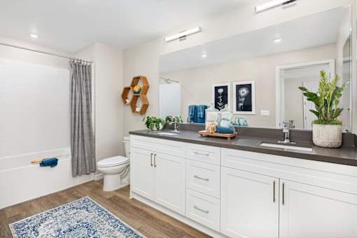 A bathroom with a white tub, toilet, and sink.