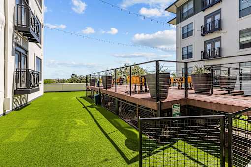 A rooftop garden with artificial grass and a tennis court.