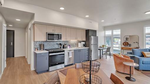 A modern kitchen with a dining area and a living room.