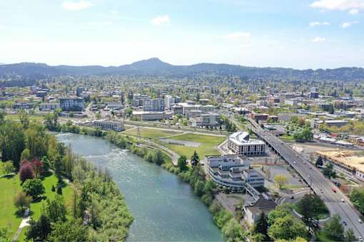 A river flows through a city with a bridge crossing over it.
