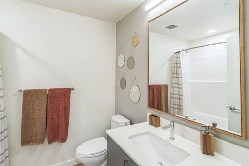 A bathroom with a toilet, sink, and towel rack.