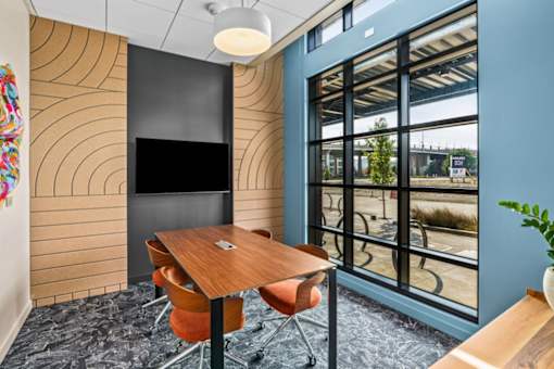 A conference room with a wooden table and chairs.
