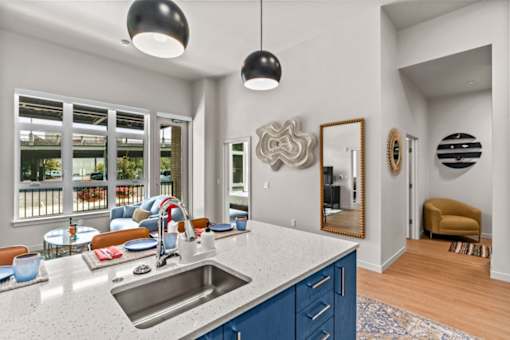 A modern kitchen with a large island and a view of the backyard.
