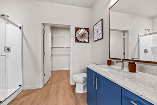 A bathroom with a toilet, sink, and mirror.