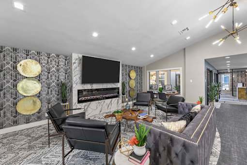 A modern living room with a grey sofa, a coffee table, and a fireplace.