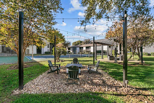 A park with a table and chairs under a canopy.