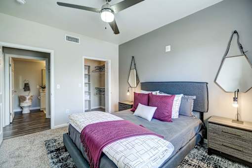 A bedroom with a bed, a ceiling fan, and a rug.
