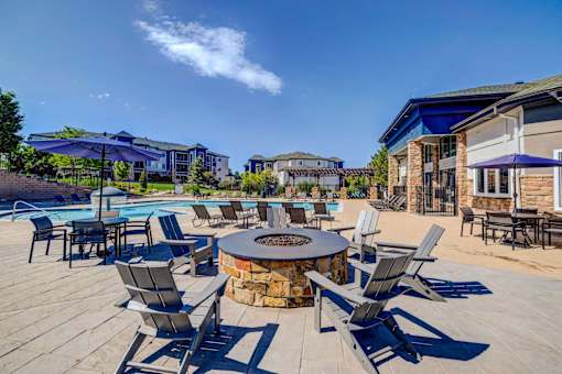A poolside area with chairs and a fire pit.