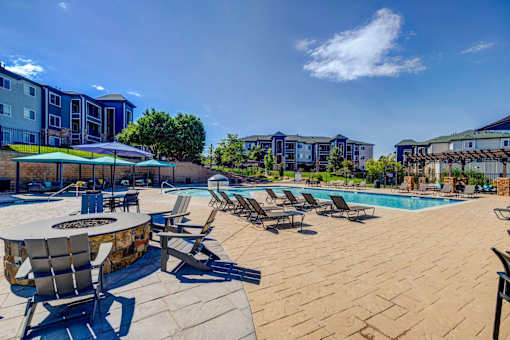 A poolside area with chairs and a table.