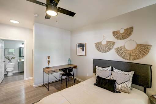 A bedroom with a bed, desk, and chair.