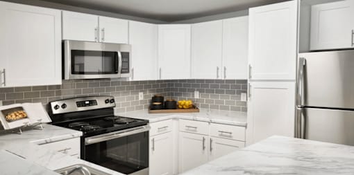 A kitchen with white cabinets and a black stove top oven.