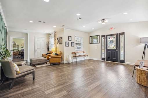 A spacious waiting room with wooden floors and comfortable seating.