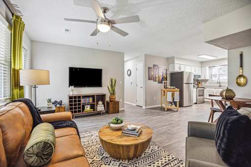 A living room with a brown leather couch and a wooden coffee table.