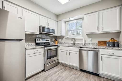 A kitchen with white cabinets and stainless steel appliances.