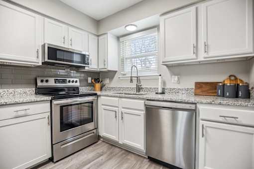 A kitchen with white cabinets and stainless steel appliances.