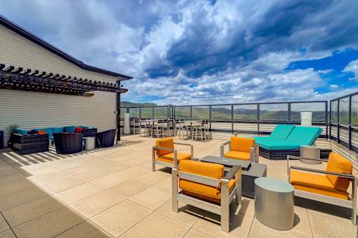 A patio with orange chairs and a table.