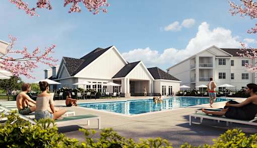 People are relaxing by the pool in front of a large building.
