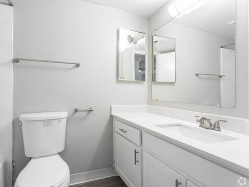 A white toilet sits next to a sink in a small bathroom.
