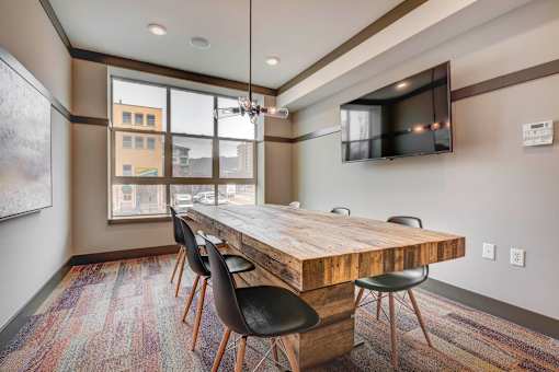 A conference room with a long wooden table and chairs.