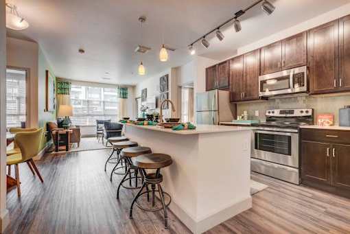 A kitchen with a white island and wooden cabinets.