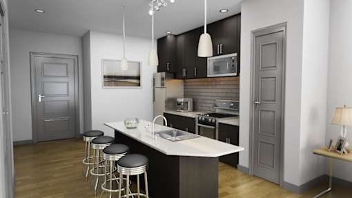 A modern kitchen with a white island and black cabinets.