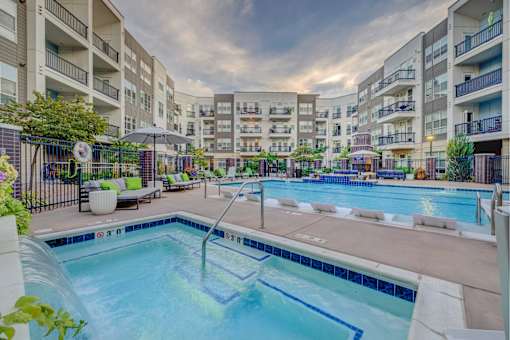 A swimming pool in a residential area surrounded by apartment buildings.
