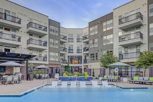 A large swimming pool in front of apartment buildings.