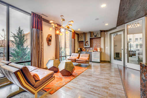 A modern living room with a large window and a view of trees outside.