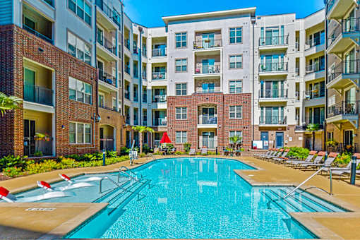 A swimming pool in front of apartment buildings.