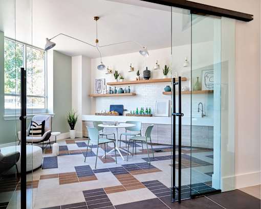 A modern kitchen with a glass door and a tiled floor.