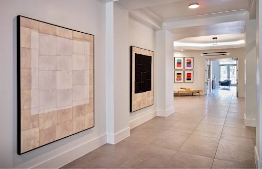A hallway with two paintings on the wall.