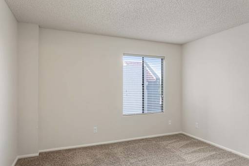 A room with a window covered by blinds.