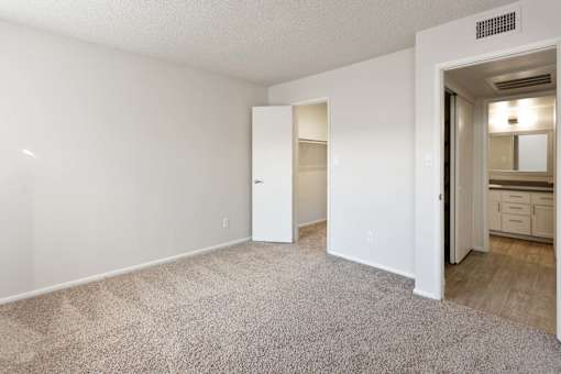 A room with a carpeted floor and a doorway leading to another room.