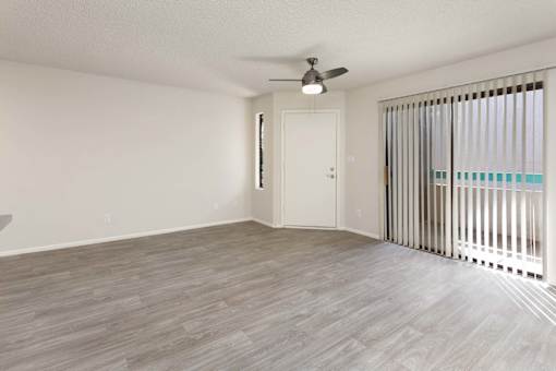A room with a ceiling fan and a door.