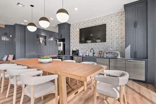A modern kitchen with a wooden table and chairs.