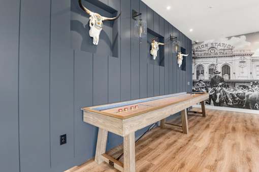 A pool table in a room with a cow skull on the wall.